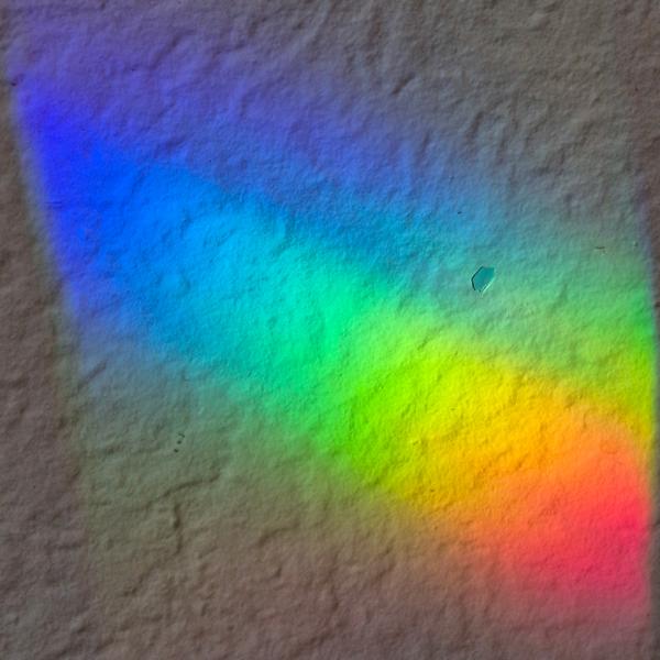 A beautiful SunRain prism suncatcher casting vibrant rainbow patterns in a sunny room
